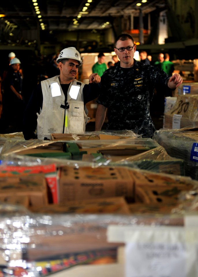 US Navy 101216-N-5016P-075 Lt. Daniel Metz, right, and Chief Logistics Specialist Daniel Hernandez organize pallets of supplies during a replenishm