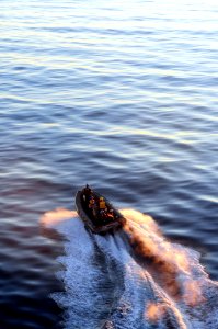 US Navy 101213-N-3659B-087 Sailors maneuver a rigid-hull inflatable boat to pick up passengers alongside the amphibious dock landing ship USS Comst