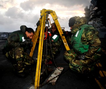 US Navy 101213-N-7103C-015 Sailors use an industrial tripod to raise an arresting gear wire during scheduled maintenance aboard USS George Washingt