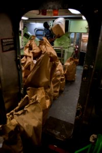 US Navy 101213-N-7981E-052 Machinist's Mate Fireman Recruit Khaliem Rogers loads paper garbage into an incinerator in the waste processing room abo