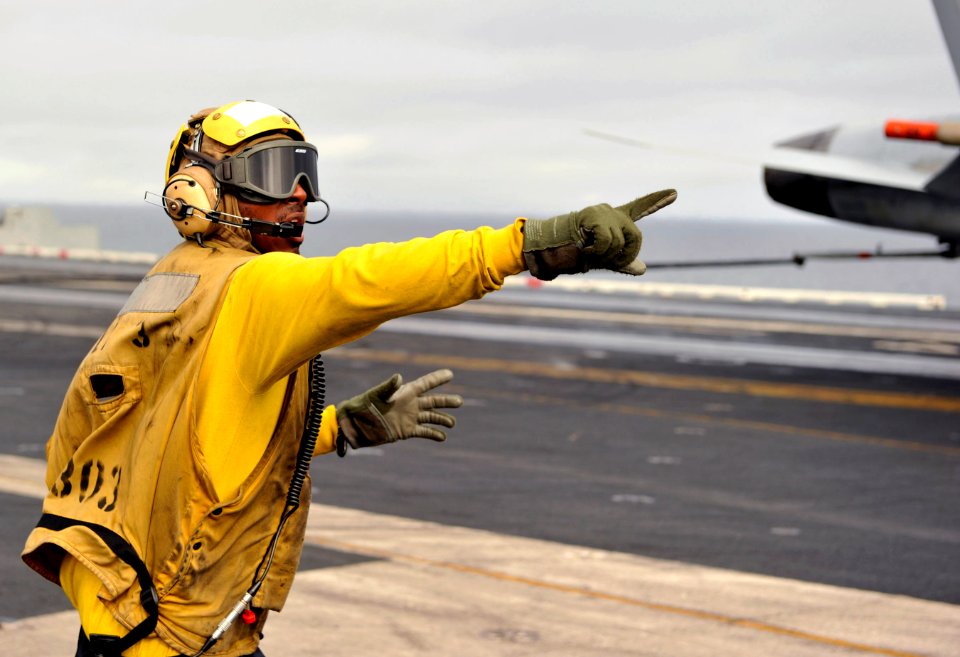 US Navy 101217-N-2953W-093 Aviation Boatswain's Mate (Handling) 3rd Class Rodney Bailey shouts for air department personnel aboard the aircraft car