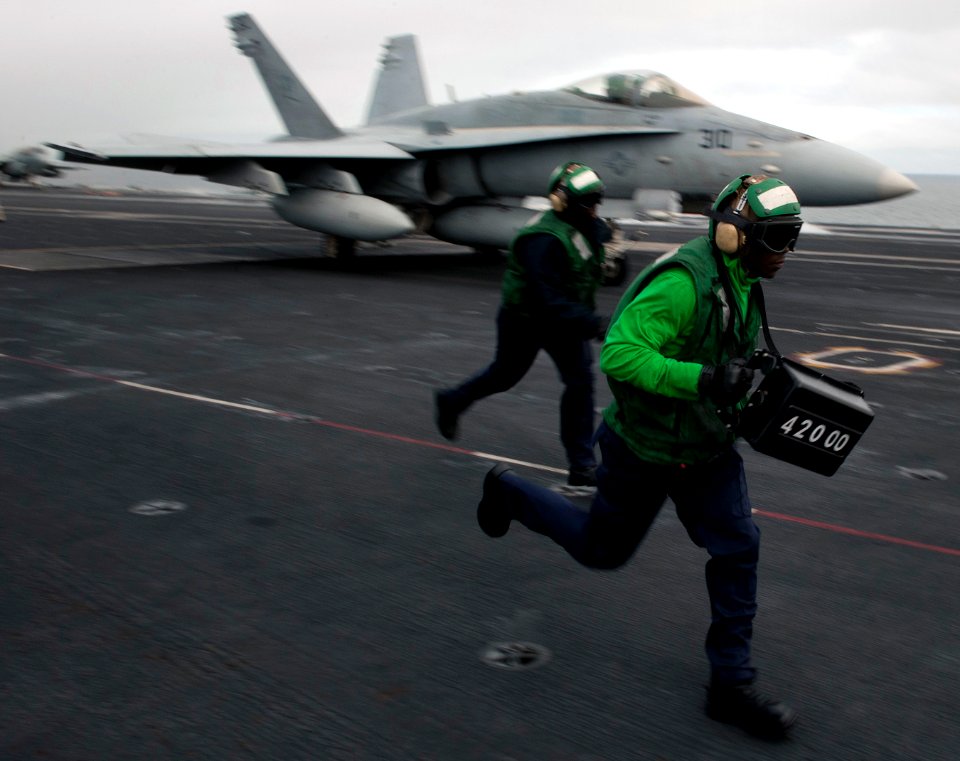 US Navy 101217-N-7981E-093 Aviation Boatswain's Mate (Equipment) Airman Terrance Chase displays the weight of an F-A-18C Hornet