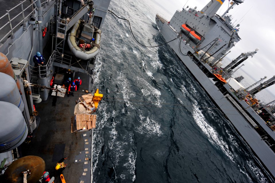 US Navy 101214-N-6006S-075 Sailors aboard the guided-missile cruiser USS Bunker Hill (CG 52) receive supplies during a replenishment at sea with t