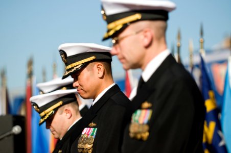 US Navy 101217-N-5758H-033 Cmdr. H.B. Le, center, bows his head during the reading of the invocation at the change of command ceremony of USS Lasse