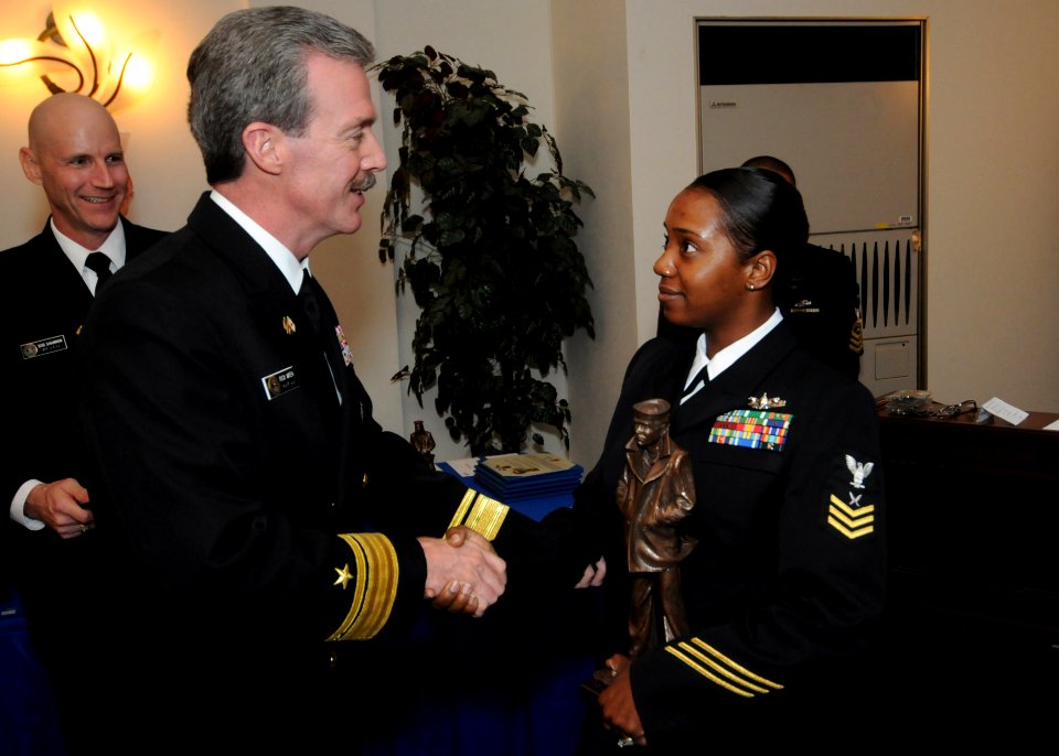 US Navy 101216-N-3283P-002 Rear Adm. Rick Wren apresents Yeoman 1st Class Nashera Brown the Sailor of the Year during a luncheon at Fleet Activitie