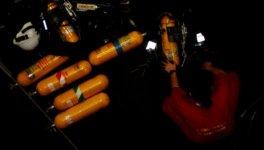 US Navy 101216-N-2475A-294 Damage Controlman 3rd Class Megan Lofton, from Atlanta, Texas, examines self-contained breathing apparatus bottles in ha