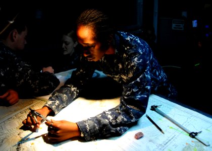 US Navy 101217-N-4590G-067 Operations Specialist 2nd Class Kanisha Toomer uses a divider to plot the location of USS Ronald Reagan (CVN 76)