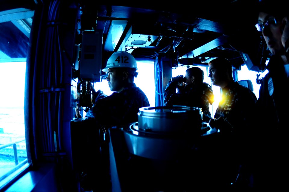 US Navy 101216-N-7939W-091 Capt. Paul O. Monger and crewmembers watch shipyard personnel tow USS Nimitz (CVN 68) into a dry dock