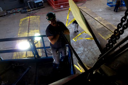 US Navy 101216-N-9643K-139 A General Dynamics shipyard worker uses a bar for leverage to loosen bolts in preparation to remove the starboard propel