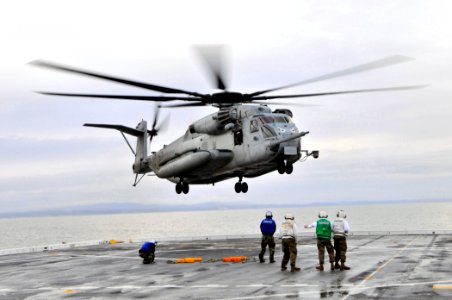 US Navy 101216-N-7042V-010 Sailors watch as a CH-53 Sea Stallion helicopter repares to land aboard USS Green Bay (LPD 20)