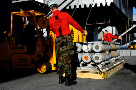US Navy 101217-N-2475A-104 Sailors load ordnance onto pallets on elevator two during an ammunition onload aboard the aircraft carrier USS John C. S