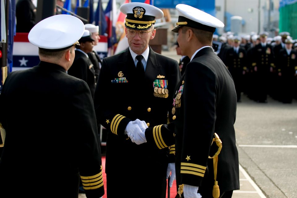 US Navy 101217-N-5758H-067 Capt. William T. Wagner, left, and Cmdr. H.B. Le, right, congratulate Cmdr. Walter C. Wrye IV as the new commanding offi
