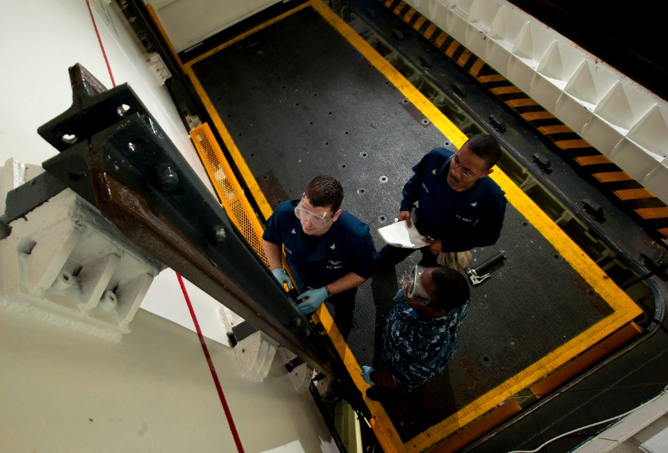 US Navy 101218-N-7981E-066 Sailors inspect a guide rail on an upper stage weapons elevator aboard USS Carl Vinson (CVN 70)