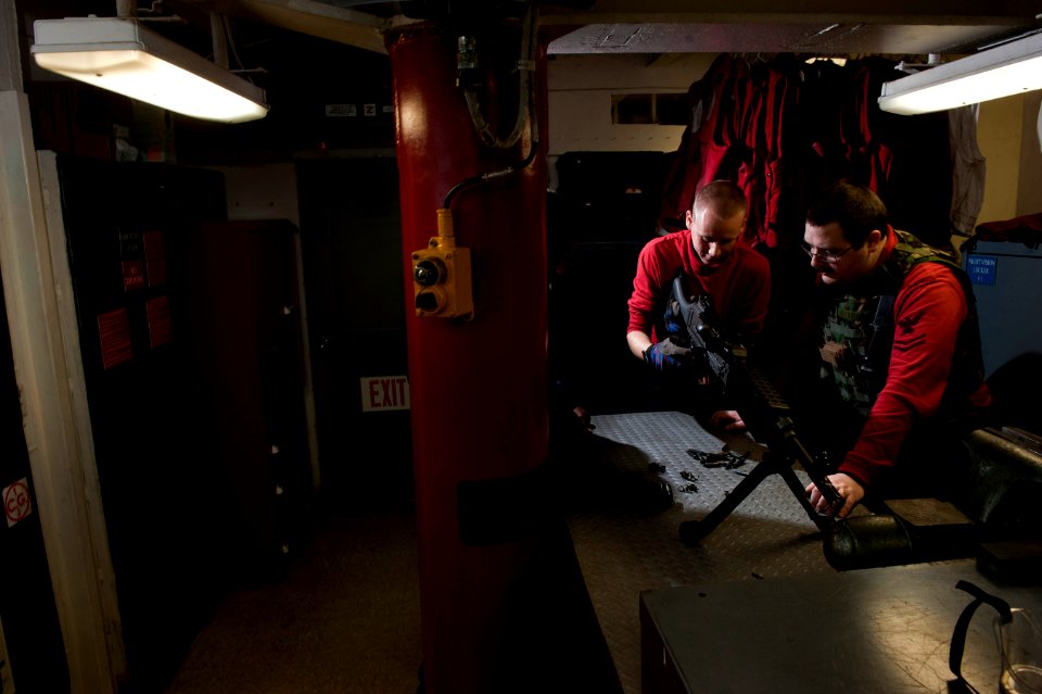 US Navy 101219-N-7981E-157 Gunner's Mate 2nd Class Ralph Bucci, right, conducts general weapons instruction on an M-240 machine gun with Gunner's M