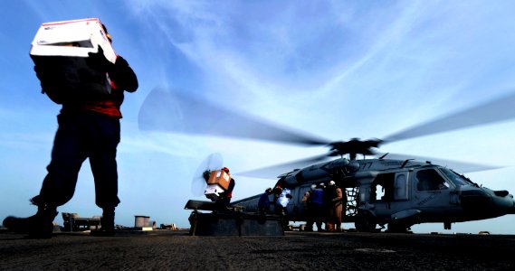 US Navy 101218-N-6266K-086 Sailors assigned to the guided-missile destroyer USS O'Kane (DDG 77) offload cargo from an MH-60S Sea Hawk helicopter du