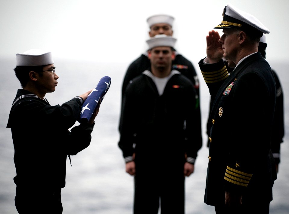 US Navy 101227-N-2055M-517 Capt. Bruce H. Lindsey salutes the national ensign during a burial at sea aboard USS Carl Vinson (CVN 70)