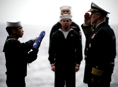 US Navy 101227-N-2055M-517 Capt. Bruce H. Lindsey salutes the national ensign during a burial at sea aboard USS Carl Vinson (CVN 70)
