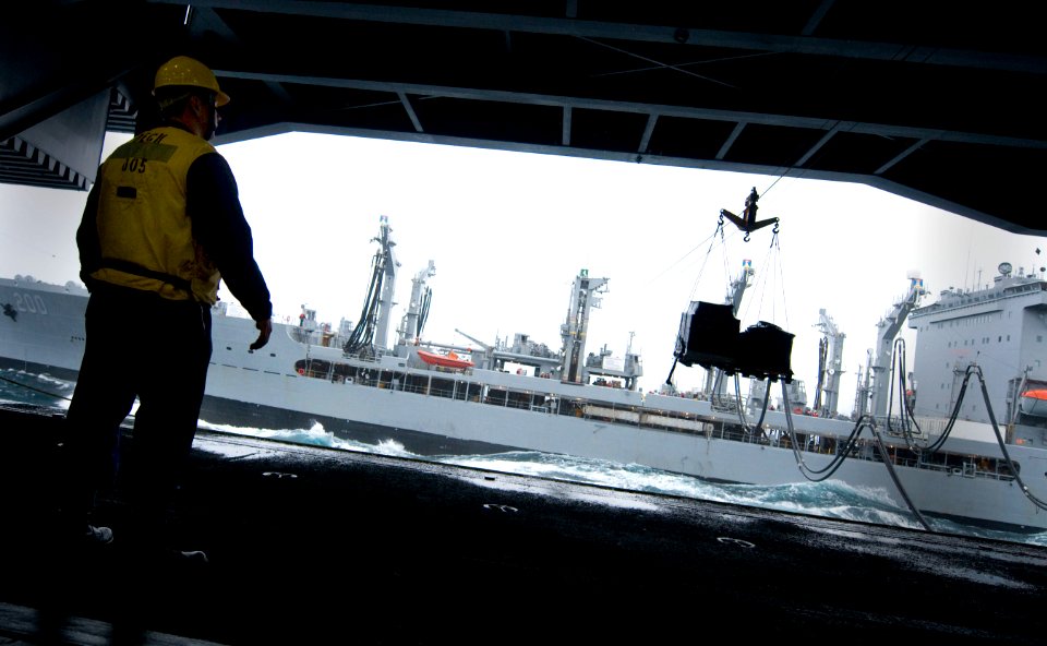 US Navy 101221-N-2055M-081 Boatswain's Mate 3rd Class Christopher Cook watches stores cross from the Military Sealift Command fleet replenishment o