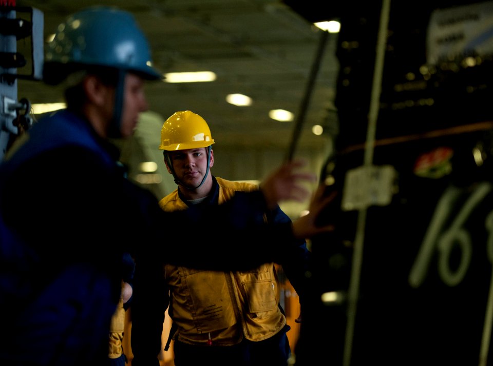 US Navy 101221-N-7981E-196 Boatswain's Mate 3rd Class Christopher Cook supervises riggers as stores are received aboard the aircraft carrier USS Ca