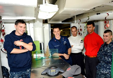 US Navy 101221-N-2821G-012 Sailors aboard the the aircraft carrier USS Abraham Lincoln (CVN 72) gather around an intercom phone to speak with Bosto