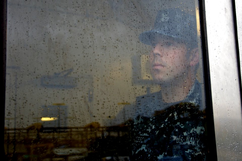 US Navy 101221-N-9643K-493 Cryptologic Technician (Collection) 2nd Class Zachary Jacobson keeps an eye on the ship as he stands watch on the messin