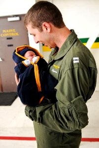 US Navy 101219-N-8590G-007 Lt. Daniel Clayton embraces his newborn son for the first time during a homecoming celebration for the Dusty Dogs of Hel photo