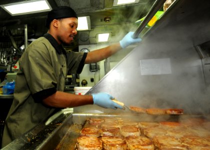 US Navy 110124-N-9793B-024 Culinary Specialist Seaman Diante A. Johnson prepares pork chops in the ship's galley photo