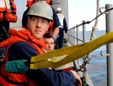 US Navy 101227-N-0864H-402 Seaman Joshua Vickery is strapped in a safety harness as he prepares to lower the search and rescue swimmer into the wat