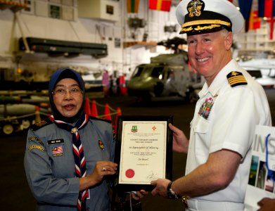 US Navy 110123-N-7981E-194 Capt. Bruce Lindsey accepts a certificate of appreciation from headmistress Nik Nab and scouts from SK Taman Tun Dr. Ism