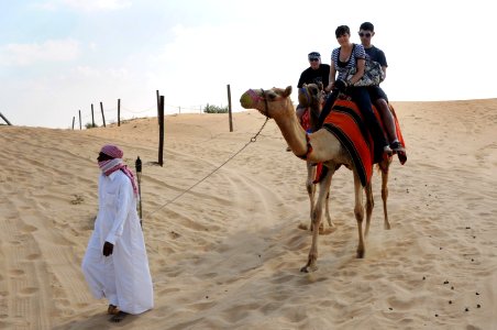 US Navy 101225-N-7095C-330 Sailors deployed aboard the aircraft carrier USS Abraham Lincoln (CVN 72) ride camels while on liberty in the desert out