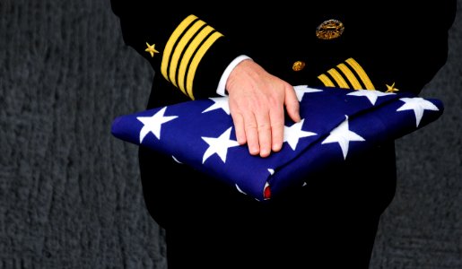 US Navy 101227-N-7488A-079 Capt. Bruce H. Lindsey holds the national ensign during a burial at sea aboard USS Carl Vinson (CVN 70)