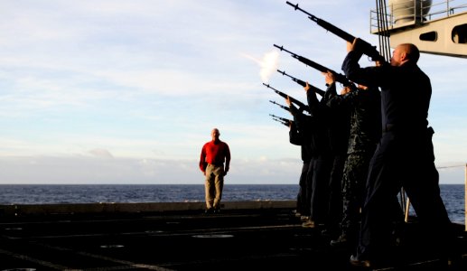 US Navy 101223-N-8040H-095 Senior Chief Gunner's Mate Zachary Eubanks shouts orders as Sailors in a burial detail fire a rifle volley during a bur photo