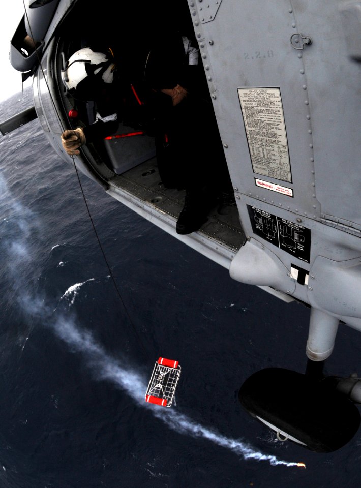 US Navy 110125-N-6632S-506 Naval Air Crewman 2nd Class Nathaniel Sniff lowers a rescue basket