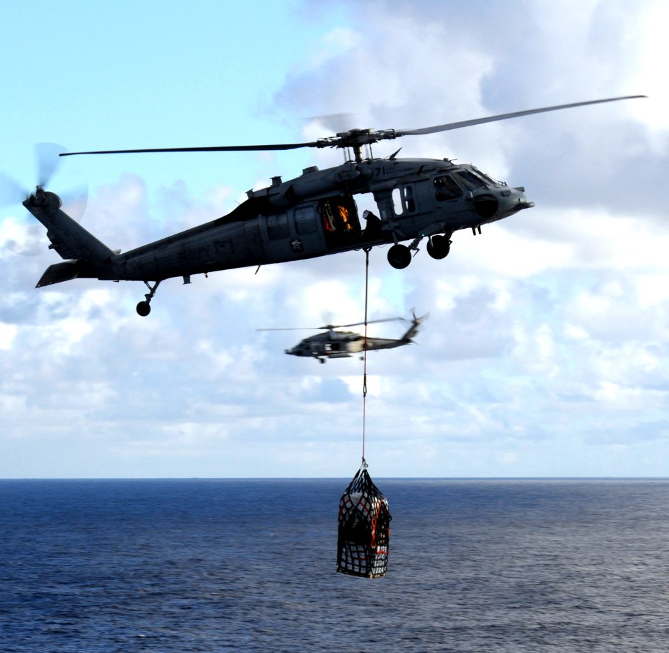 US Navy 101229-N-8040H-037 An MH-60S Sea Hawk helicopter assigned to Helicopter Sea Combat Squadron (HSC) 21 transports cargo to the aircraft carri