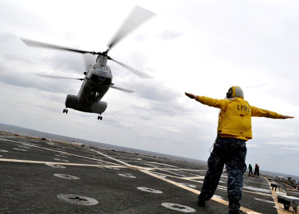 US Navy 110126-N-3620B-066 Aviation Support Equipment Technician 2nd Class Dean McRae signals a CH-46E Sea Knight helicopter, assigned to the Flyin
