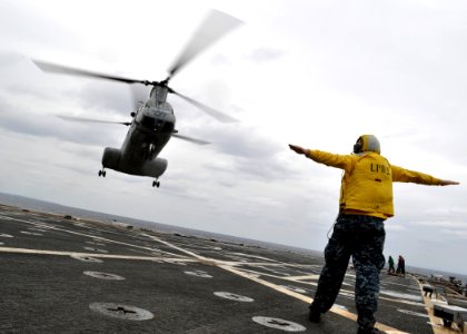 US Navy 110126-N-3620B-066 Aviation Support Equipment Technician 2nd Class Dean McRae signals a CH-46E Sea Knight helicopter, assigned to the Flyin