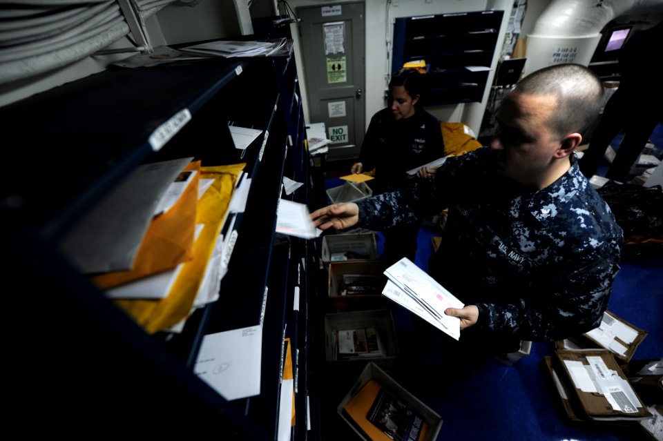 US Navy 110121-N-2475A-118 Logistics Specialist 2nd Class Matthew Cummings, right, and Logistics Specialist 2nd Class Marlene Walton sort mail in t