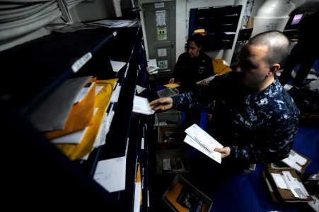 US Navy 110121-N-2475A-118 Logistics Specialist 2nd Class Matthew Cummings, right, and Logistics Specialist 2nd Class Marlene Walton sort mail in t
