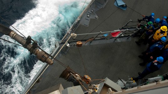 US Navy 110126-N-9589S-112 Sailors aboard the Arleigh Burke-class guided-missile destroyer USS Truxtun (DDG 103) guide a fuel line during an underw photo