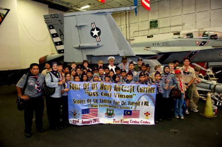 US Navy 110123-N-7981E-203 Capt. Bruce Lindsey has his photo taken with scouts from SK Taman Tun Dr. Ismail 1KL High Performance School during a to