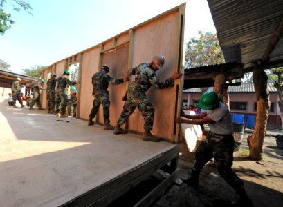 US Navy 110124-N-7589W-031 Sailors assigned to Naval Mobile Construction Battalion (NMCB) 28 and Marines with 2nd Marine Logistics Group raise a wa