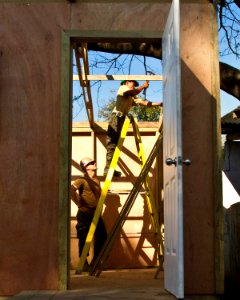 US Navy 110127-N-6724S-249 Builder 2nd Class Andreas Toth, left, helps a Guatemalan Jefatura de Mantenimiento sailor nail the roof support of a sou