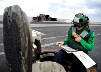US Navy 110123-N-4973M-028 Aviation Boatswain's Mate (Equipment) 3rd Class Shannon Eck speaks to catapult crew members from the center deck operato