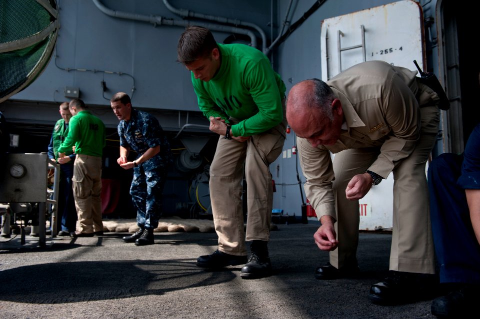 US Navy 110131-N-7981E-110 Rear Adm. Samuel Perez assists Sailors in a foreign object damage walk down on the fantail of SS Carl Vinson (CVN 70)