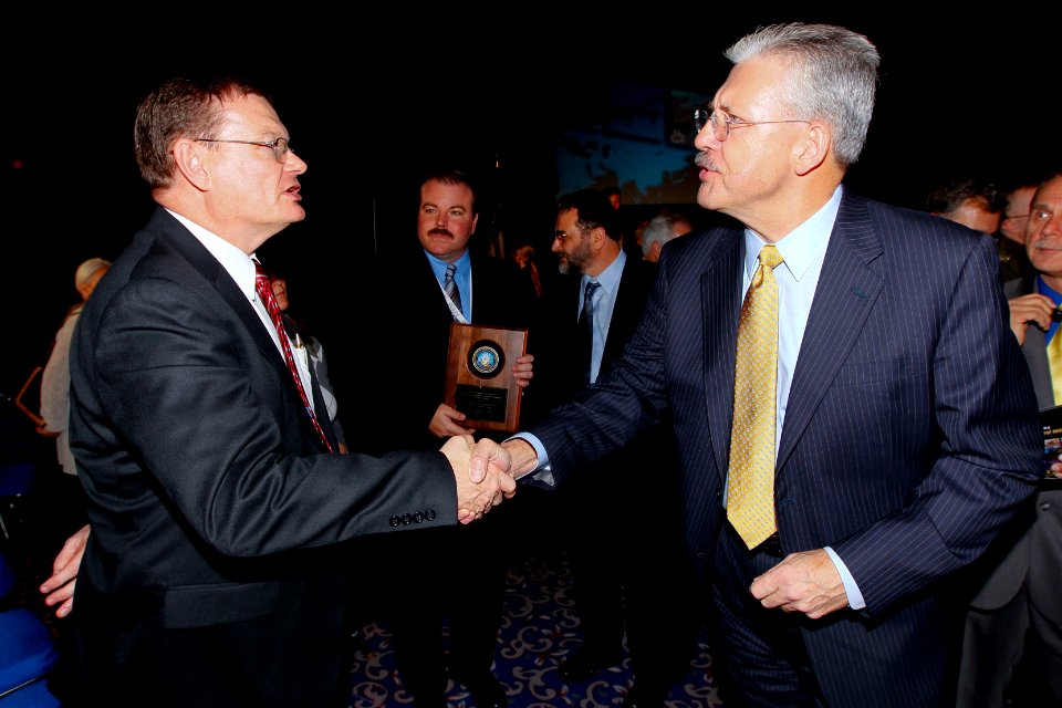 US Navy 110125-N-8863V-245 Department of the Navy Chief Information Officer Terry A. Halvorson congratulates Dr. William Leubke