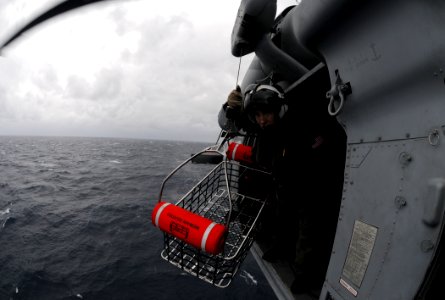 US Navy 110125-N-6632S-677 Naval Air Crewman 2nd Class Nathaniel Sniff lowers a rescue basket