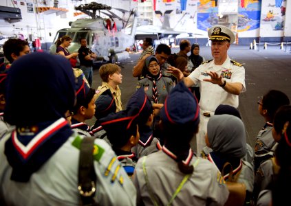 US Navy 110123-N-7981E-292 Capt. Bruce Lindsey peaks to scouts from SK Taman Tun Dr. Ismail 1KL High Performance School during a tour of the ship