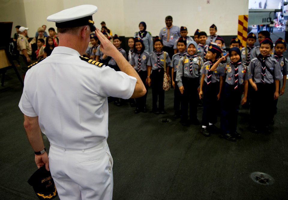 US Navy 110123-N-7981E-171 Capt. Bruce Lindsey salutes scouts from SK Taman Tun Dr. Ismail 1KL High Performance School during a tour of USS Carl Vi