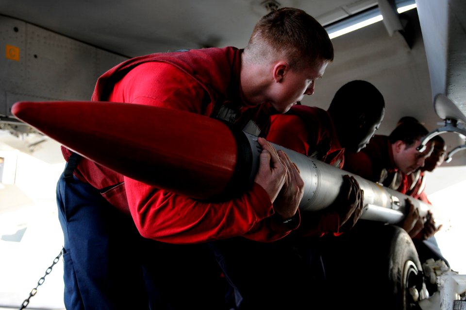 US Navy 110201-N-8040H-259 Sailors assigned to Strike Fighter Squadron (VFA) 81 load an AIM-120 advanced medium range air-to-air missile onto an F