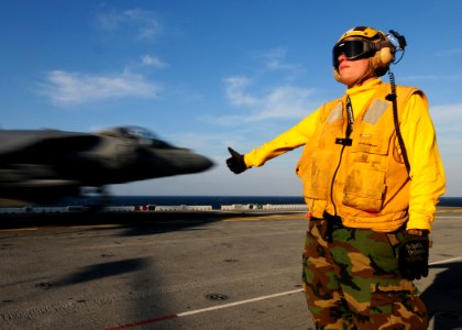 US Navy 110202-N-5538K-097 Aviation Boatswain's Mate Airman Jeremy J. New gives the okay signal as an AV-8B Harrier jet aircraft